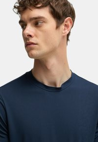 T-shirt blu navy a maniche corte in tessuto morbido con scollatura rotonda. Presenta un design minimalista senza motivi o loghi visibili.