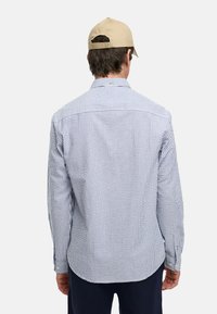 Blauw en wit gestreepte langarm shirt met een button-down kraag, voorzien van een yoke ontwerp en met knoopmanchetten. Het materiaal lijkt lichtgewicht.