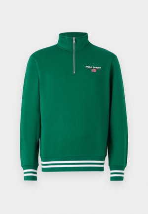 Pullover verde in pile con colletto alto e zip a quarto. Presenta polsini e orlo a righe bianche, e il logo "POLO SPORT" con un design a bandiera.