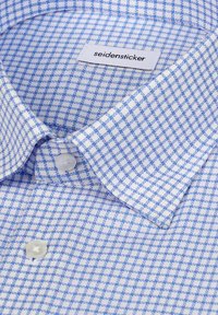 Niebiesko-biała koszula w kratę z kołnierzykiem na guziki, wykonana z lekkiego materiału. Etykieta z napisem "seidensticker." Widoczny wyraźny detal guzika.