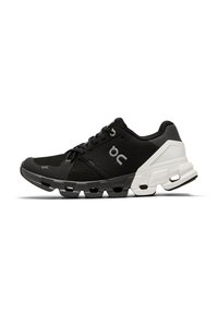 Black athletic shoe with a mesh upper, contrasting white heel, padded collar, and a textured sole featuring prominent cushioning elements.