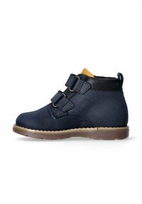 Stivale alla caviglia per bambini blu navy con doppie chiusure a strappo, suola beige, colletto nero e linguetta imbottita marrone su sfondo bianco.