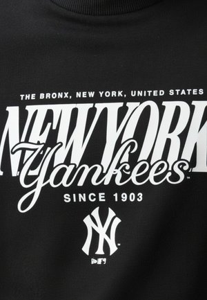 Tela negra con texto blanco que muestra "El Bronx, Nueva York, Estados Unidos", "New York Yankees", "Desde 1903" y el logo de los Yankees debajo.