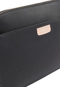 Zwarte leren pouch met textuur, voorzien van een gouden rits en een gouden merkplaat met de tekst "Paul Costelloe" op het voorvak.