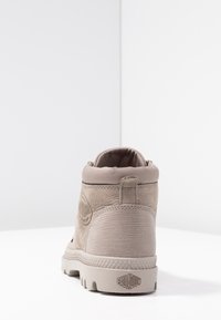 Bota beige de cuero sintético de media caña hecha de ante texturizado y goma, con un cuello acolchado, acento de logo y suela robusta para tracción.