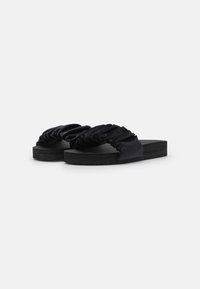 Black slide sandals with gathered fabric straps, soft texture, and flat rubber soles, designed for comfort and casual wear.