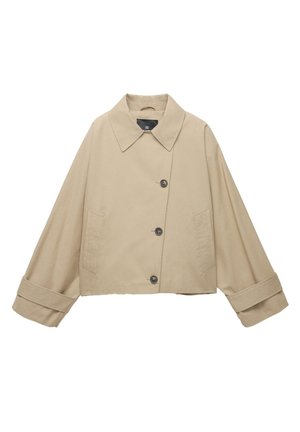 Veste cropped beige avec un large col, de grands boutons et des manches longues. Présente des poches latérales et une texture de tissu lisse.
