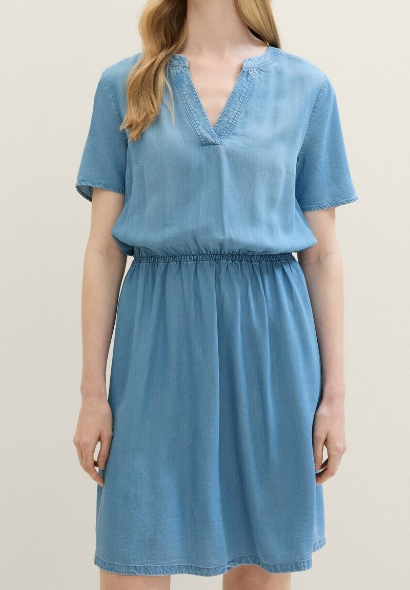 Lichtblauwe denim jurk met een relaxed fit, korte mouwen, een V-halslijn en een elastische tailleband. Kenmerkt zich door een zachte textuur en een jurk tot op de knie.