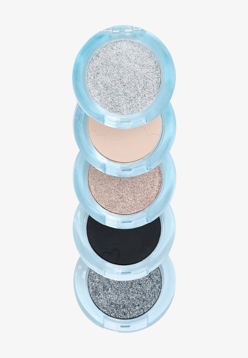Cuatro polveras redondas de sombra de ojos están apiladas. Los colores incluyen glitter plateado, beige claro, brillo rosa y negro mate. Estuches transparentes azules.