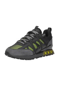 Zwarte en grijze sport sneaker met neon groene mesh details, grijze veters en een transparante gele hexagonale patroonaccentzool.