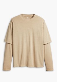 Beżowa, warstwowa koszulka z długim i krótkim rękawem, z subtelnym logo Levi's umieszczonym na środku klatki piersiowej, wyeksponowana na białym tle.