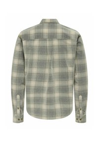 Srajca s dolgimi rokavi v karo vzorcu v zeleni in kremni barvi, izdelana iz teksturirane tkanine z gumbnimi manžetami, ki ima hrbtni del in rahlo zožanje na robu.
