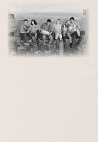 Fotografía en blanco y negro que muestra a cinco personas sentadas sobre una viga de acero sobre un paisaje urbano, con edificios urbanos destacados en el fondo.