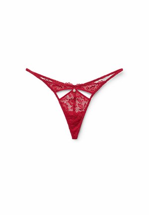 Tanga de encaje rojo con intrincados patrones florales, diseño con recortes en la parte trasera y finas tiras ajustables. Acentuado con un pequeño detalle plateado.