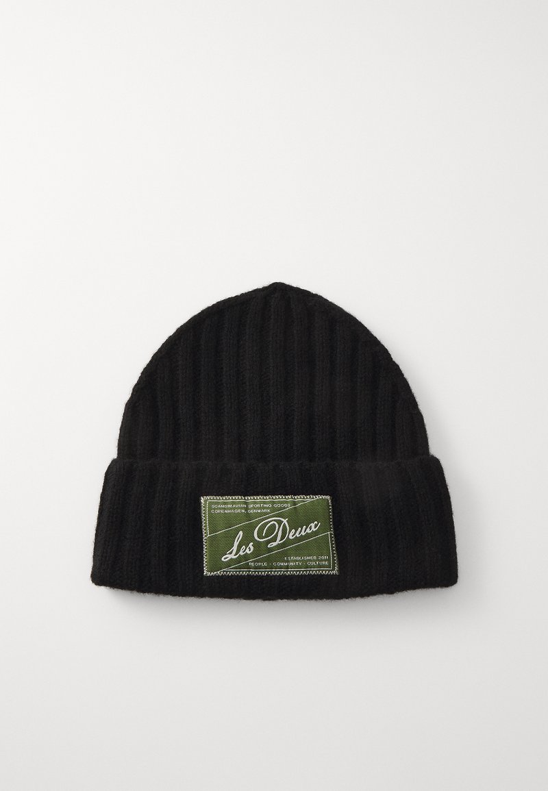 Bonnet en tricot noir à côtes avec un revers et une étiquette vert olive affichant "Les Deux" en écriture blanche. Texture lisse.