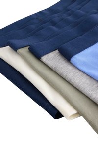 Blandet T-shirts stablet: marineblå, crème, oliven, grå og lys blå. Hver har en glat tekstur og kontrasterende manchetter.