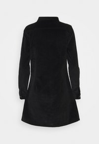 Svart kordflorsklänning med långa ärmar, knappade manschetter, krage och en utsvängd nederdel, med en texturerad tygdesign.