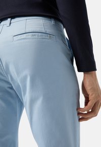 Lichtblauwe katoenbroek met een gladde structuur, voorzien van achterzakdetail en een klein logo op de tailleband.
