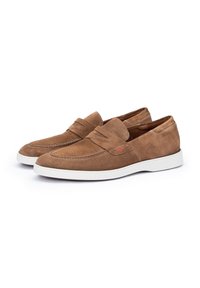 Brune ruskind loafers med et syet design, der har en hvid gummisål og en subtil rød detalje på siden.