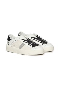 Witte leren sneakers met zwarte veters, een gestructureerde grijze streep en een zwarte hielaccent. Rondige neus en dikke rubberen zool.