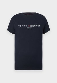 Námořnická modrá bavlněná tričko s krátkým rukávem, obsahující bílé a červené logo "TOMMY HILFIGER" a text "EST. 1985" na přední straně. Hladká textura.