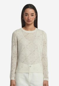 Tröja i stickad design i off-white, med ett strukturerat diamantmönster, långa ärmar och en klassisk rund halsringning. Lätt och ventilerande.