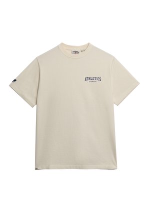 T-shirt en coton crème avec des manches courtes, un col rond et "ATHLETICS" imprimé en bleu foncé sur la poitrine gauche. Design simple et épuré.