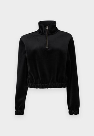 Svart, kort fleece-pullover med høy krage, glidelås og samlet midje. Lange ermer med elastiske mansjetter. Myk tekstur.