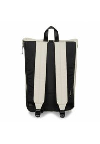 Vista posteriore di uno zaino con uno schema di colori beige e nero, con spallacci imbottiti regolabili e una maniglia superiore. Dettaglio con cerniera sul lato.