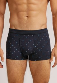 Námořnické modré boxerky s malými modro-bílými puntíky, s těsným střihem a měkkým elastickým pasem.
