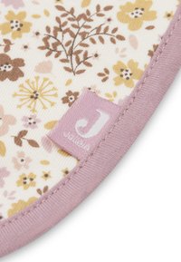 Stof met bloemenpatroon in crème met gele, bruine en rozenkleurige bloemen. Roze rand en label met "J". Zachte textuur. Ronde vorm.