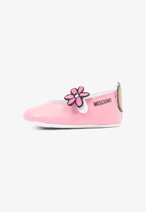 Scarpa bassa da bambina rosa con cinturino a fiore, suola bianca, marchio Moschino e dettaglio a forma di faccia di orso sul tallone.