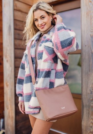 Fleece-Karojacke in Grau, Rosa und Creme mit Knöpfen und Seitentaschen; beiger Handtasche mit silbernem Akzent und Logo am unteren Rand.