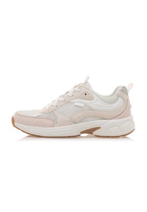 Zapatilla deportiva de color beige claro con malla y cuero liso, con acentos en blanco, punta redondeada y suela de goma con un patrón texturizado.
