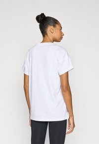 Λευκό βαμβακερό t-shirt με κοντά μανίκια, άνετη εφαρμογή, στρογγυλή λαιμόκοψη και πλευρικές σχισμές για ευκολία. Λείο ύφασμα και απλός σχεδιασμός.