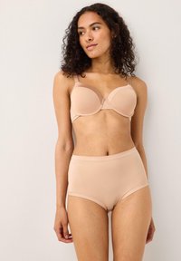 Ljusbeige trådlös bh med formade kupor och justerbara band, som matchas med högmidjade, släta beige trosor. Mjuk, elastisk tyg.