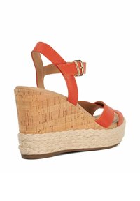 Orange leather wedge sandal with cork detail and braided jute midsole. Features an ankle strap with a gold buckle and open toe design.