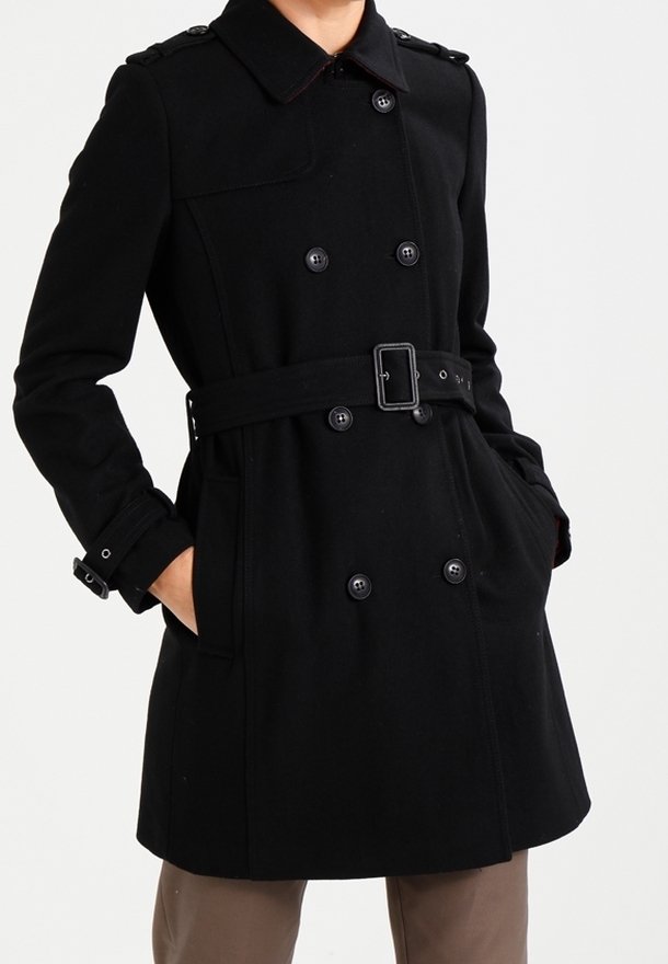 Zwarte dubbelgeknoope trenchcoat met een tailleband, grote knopen en schouderepauletten. Glad stof met een klassiek ontwerp.