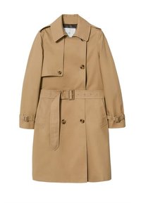 Trench-coat beige à double boutonnage avec large col, ceinture à la taille, pattes d'épaule boutonnées et brides aux poignets sur les manches longues.