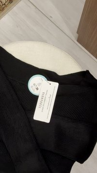 Tessuto nero a costine con superficie strutturata, con un'etichetta che indica una composizione di almeno il 70% viscosa, marchio Terranova.