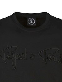 Camiseta negra con texto en relieve "Project x Paris" en la parte frontal. Diseño de cuello redondo, textura suave y mangas cortas.