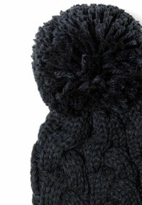 Bonnet en tricot noir avec un motif de câble texturé et un gros pompon duveteux sur le dessus. Fabriqué en fil doux et épais.