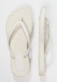 Witte flip-flops met een getextureerde, geweven zool en glanzende, gladde banden. Heeft een subtiele glinsterende uitstraling op het oppervlak van de banden.