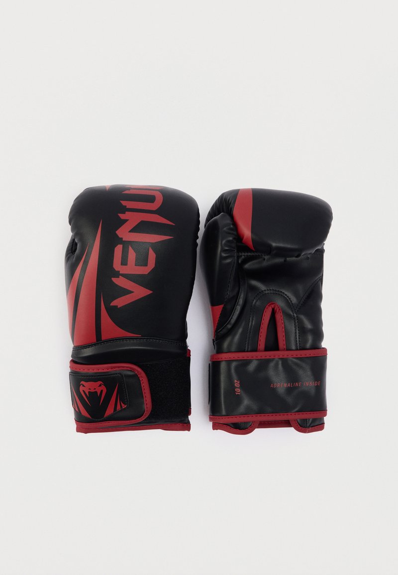 Μαύρα και κόκκινα γάντια πυγμαχίας με κομψό σχέδιο, που διαθέτουν υφή επιφάνειας, λεπτομέρεια με λογότυπο και ρυθμιζόμενα λουράκια βέλκρο. Διπλοί χρωματικοί τόνοι.