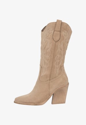 Botas de vaquero de ante color tan con detalles bordados, puntera afilada y tacón apilado de 10 cm. Pequeñas lengüetas en el tubo para facilitar su uso.