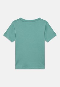 Μονόχρωμο τεϊλ κοντομάνικο μπλουζάκι, εμφανιζόμενο από πίσω, με στρογγυλή λαιμόκοψη και ραμμένο τελείωμα στα μανίκια και στο κάτω μέρος.