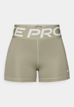 Pantaloni sportivi verde oliva realizzati in tessuto elastico, con una larga cintura bianca "NIKE PRO" e un piccolo logo Nike in basso a sinistra.