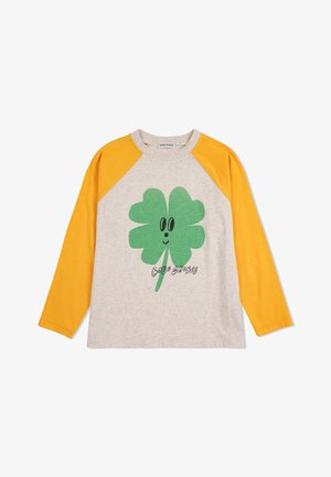 Camisa de manga larga gris con mangas raglán amarillas, que presenta un gráfico de un trébol verde y un texto negro que dice "BOBO CHOSES" debajo.