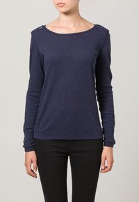 Donkerblauwe trui met lange mouwen en een ronde hals, met uitsparingen bij de schouders en een gestructureerde stof. Slim fit met geribbelde manchetten.