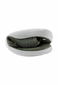 Chaussure grise en mesh pliée avec une semelle blanche texturée, montrant sa flexibilité et son amorti doux, adaptée pour un usage décontracté ou sportif.